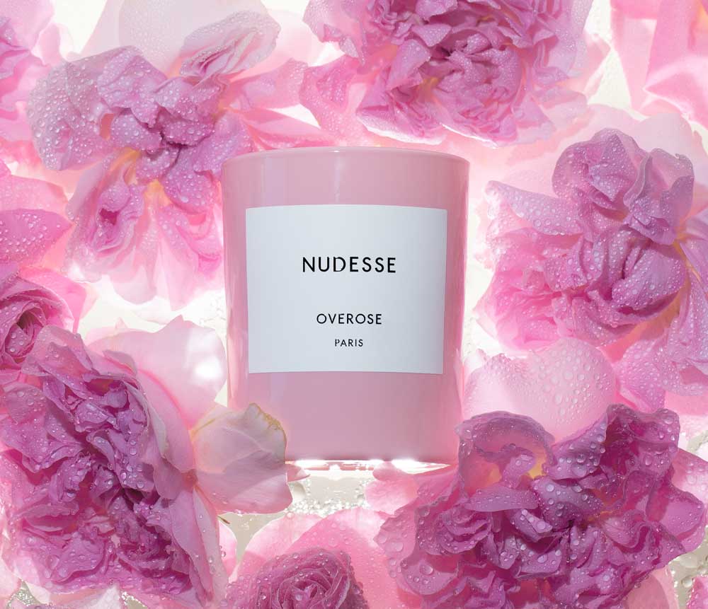 pink candle surrounded by pink roses