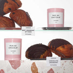 a shelf of "Pain au Chocolate" candles and chocolate Croissants