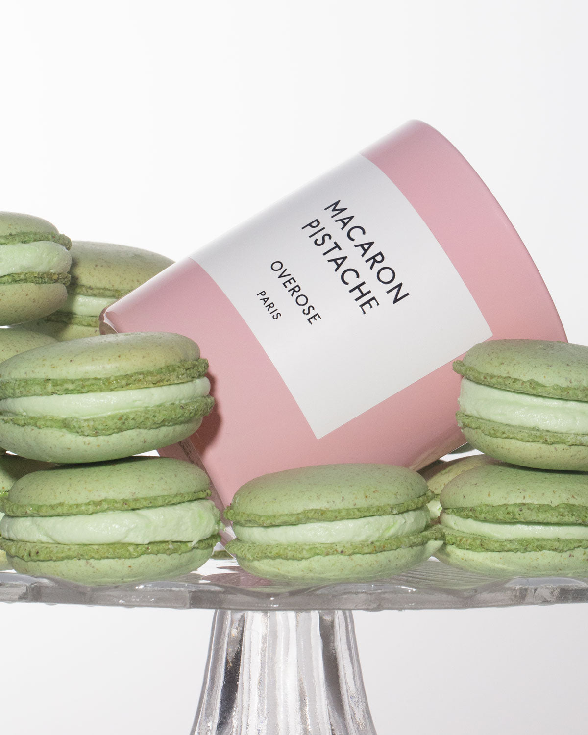 Macaron Pistachio candle surrounded by green macarons.