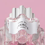 Perfume bottle with 'Overose' label on a pink background