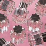 Perfume bottles with 'Overose' label on a pink background