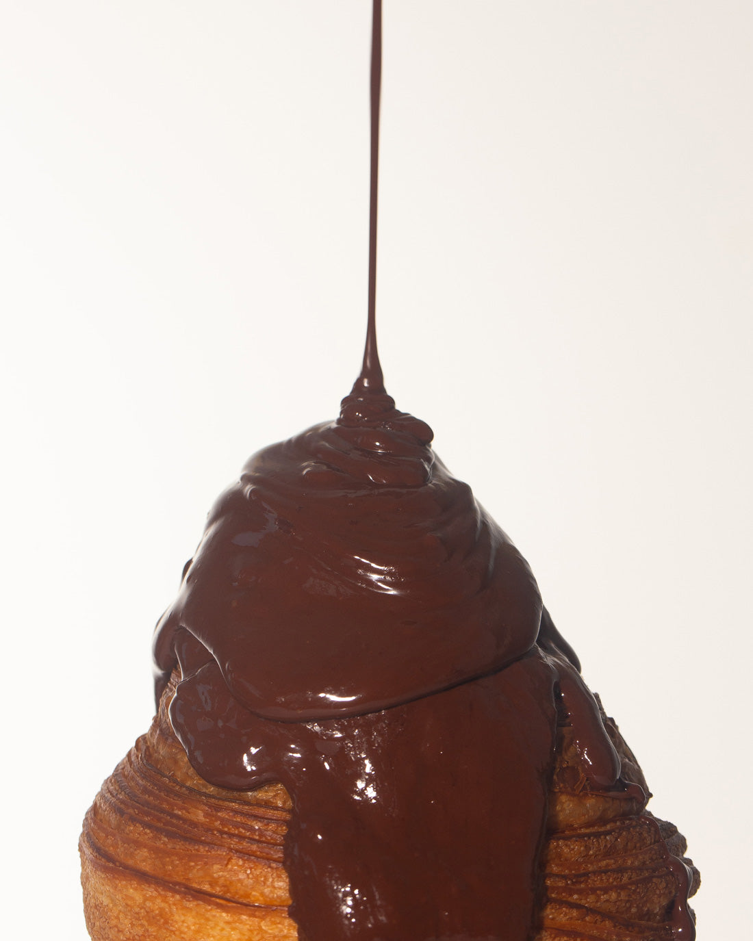 chocolate sauce melting onto a croissant