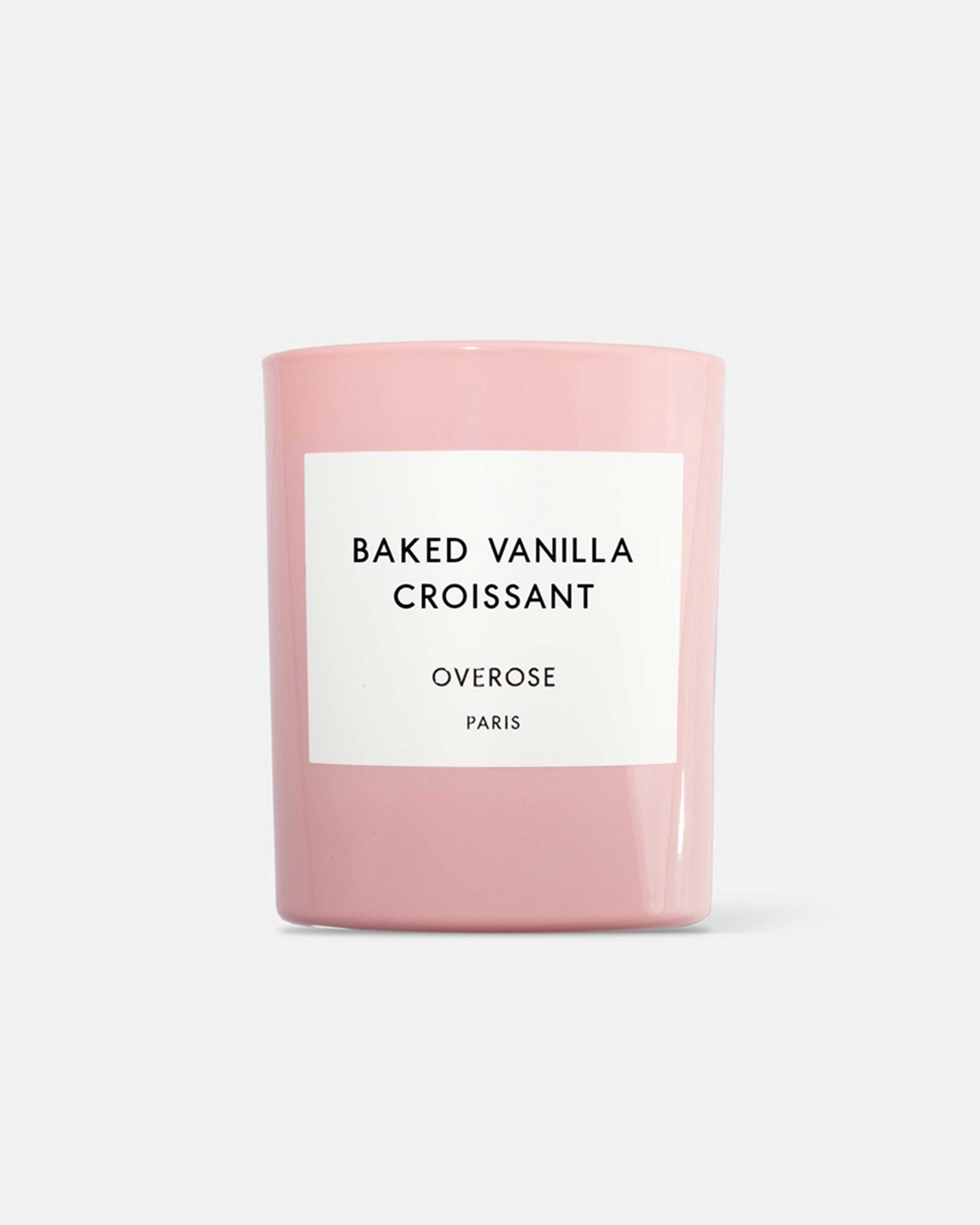 A pink candle labeled 'BAKED VANILLA CROISSANT' from the brand OVEROSE.