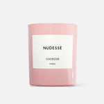 A pink candle with a white label that reads 'Nudesse Overose PARIS'.