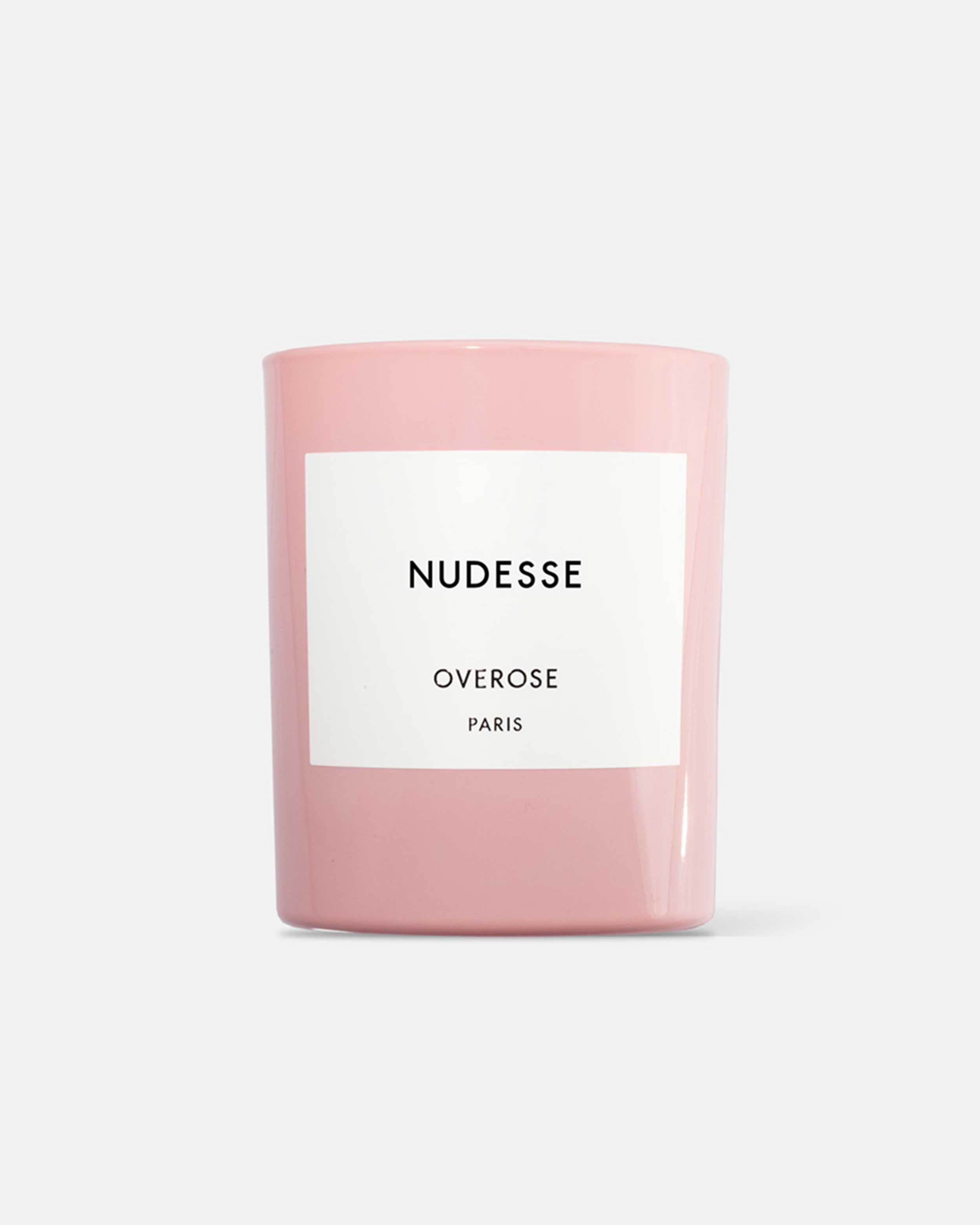 A pink candle with a white label that reads 'Nudesse Overose PARIS'.