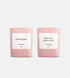 Two pink candles, one labeled 'Croissant' and the other labeled 'Pain au Chocolat', both with 'Overose, Paris' writing on the labels.