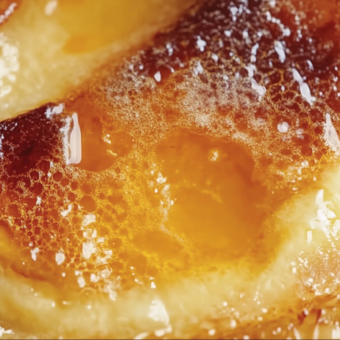 Close-up of a creme brulee custard with a golden-brown color.