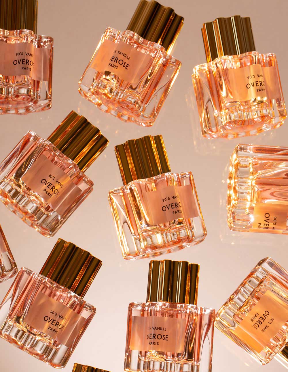Multiple bottles of Overose perfume arranged on a light background