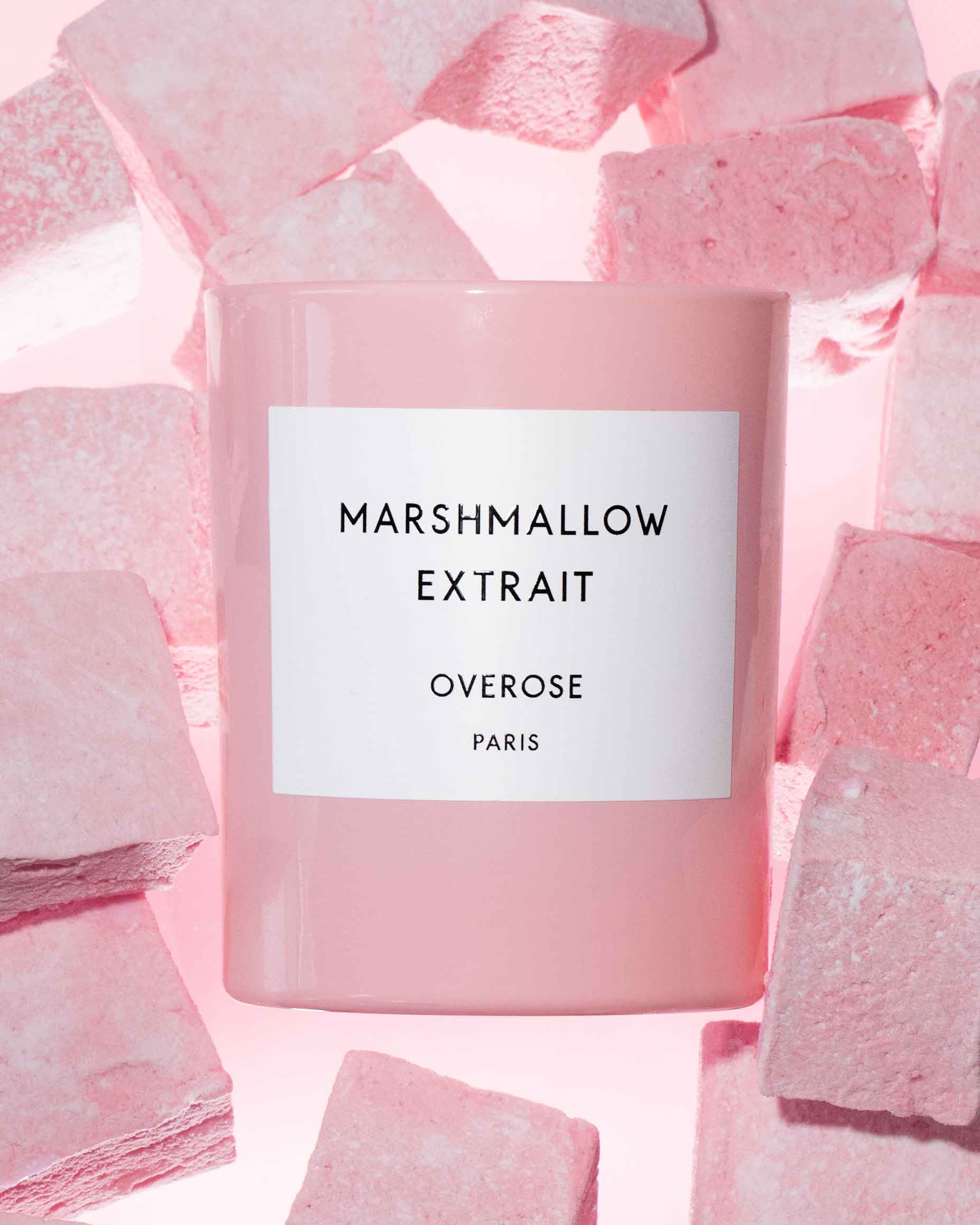 Marshmallow Extrait candle in front of pink marshmallows.