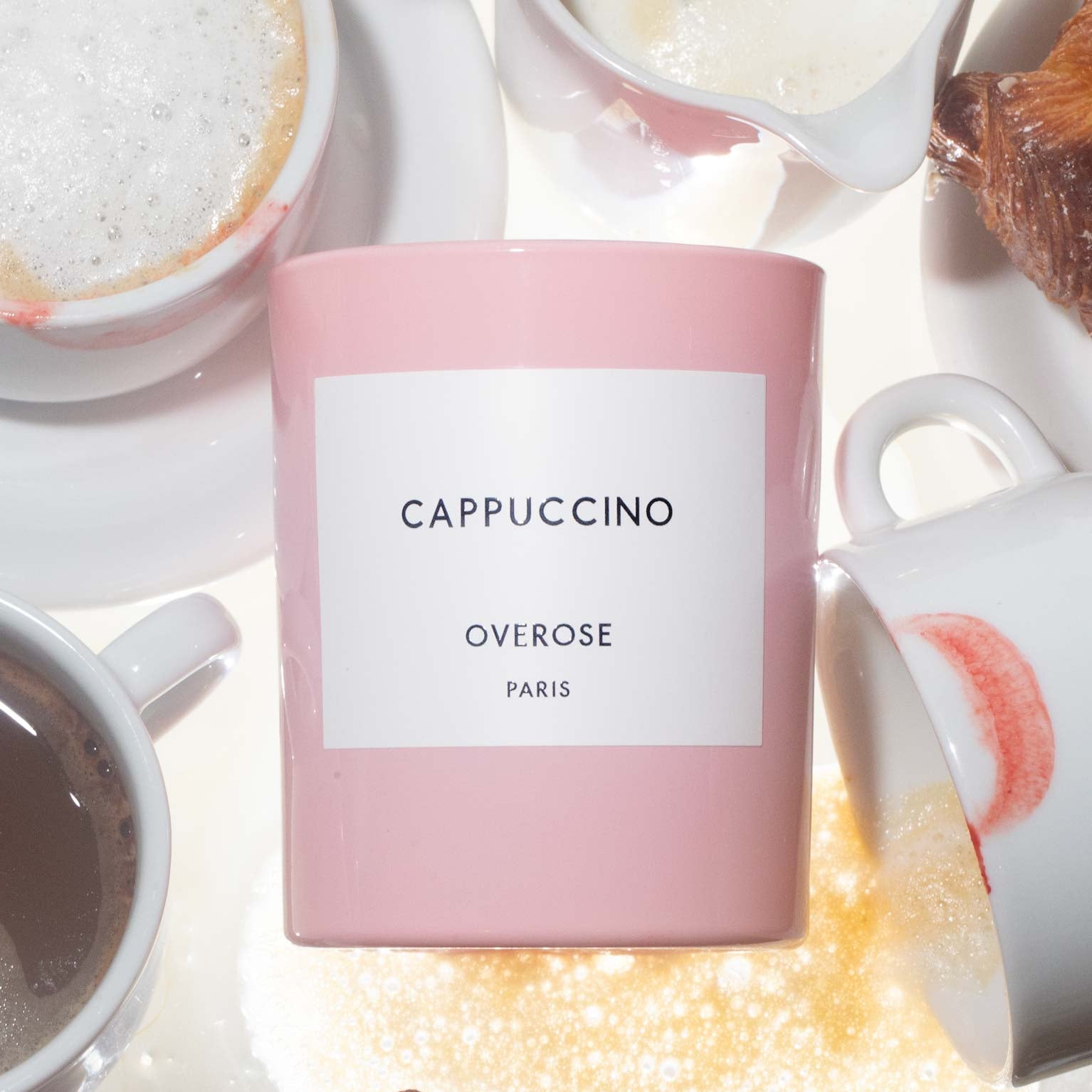 A 'Cappuccino" candle in front of Cappuccino cups 
background