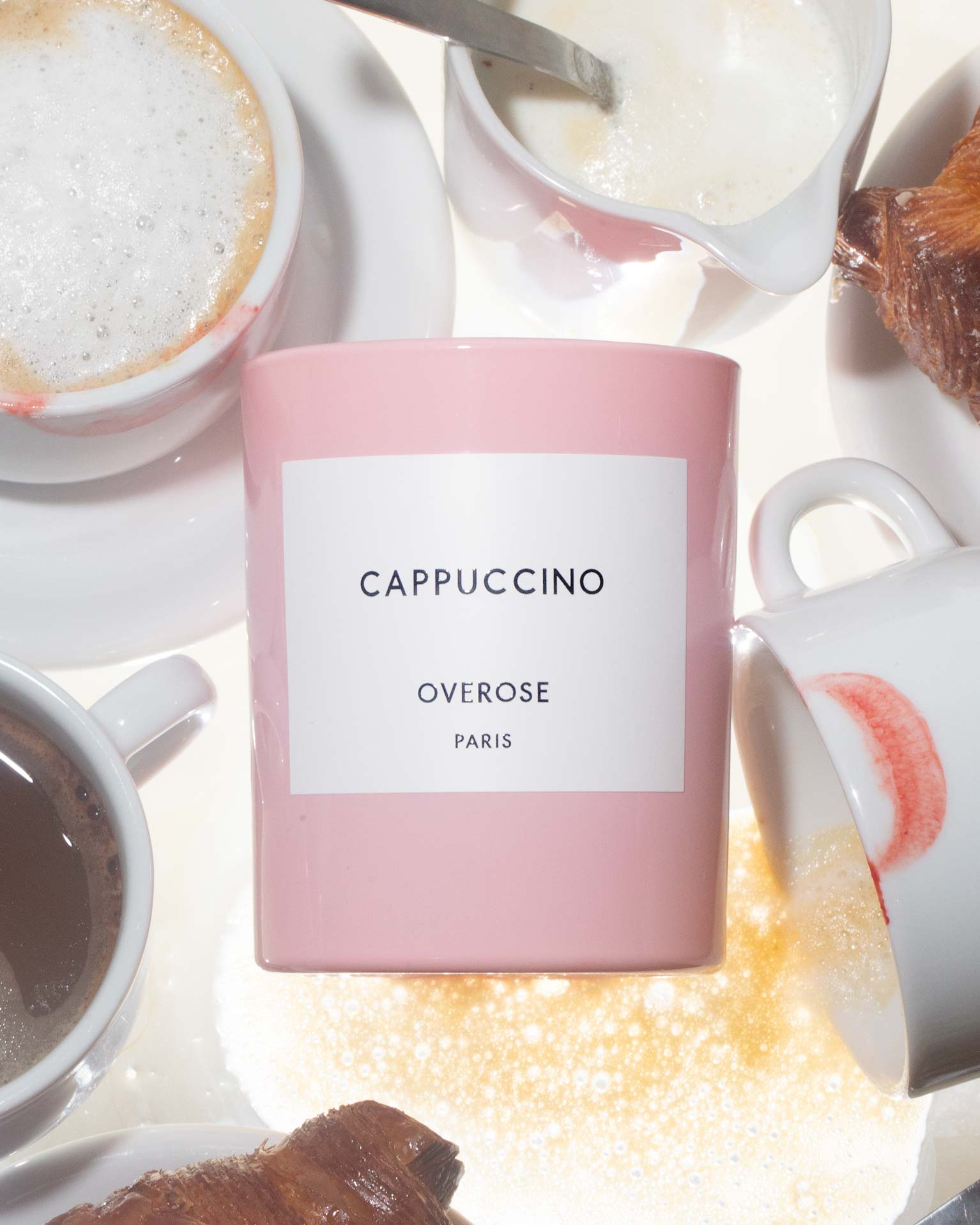 A 'Cappuccino" candle in front of Cappuccino cups 
background