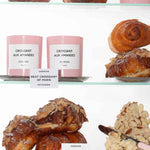 A shelf with 'Croissant aux Amandes' candles, Almond Croissant pastries and almond paste.