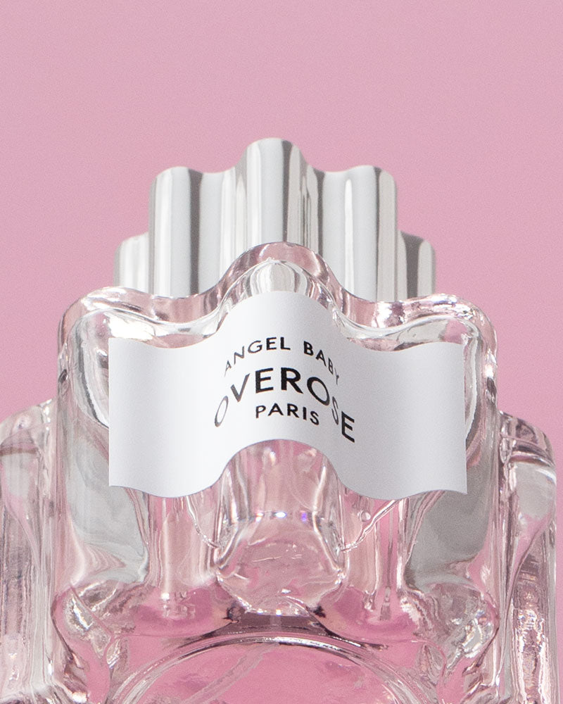 Perfume bottle with 'Overose' label on a pink background