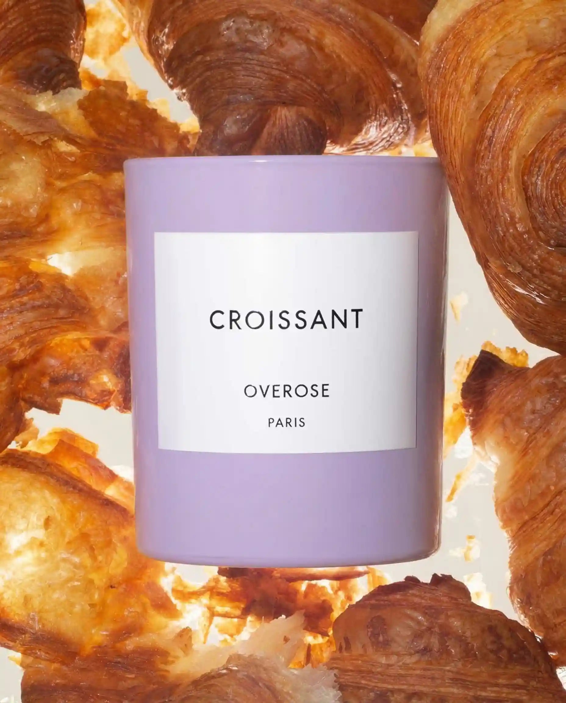 Croissant candle in purple jar in front of Croissants