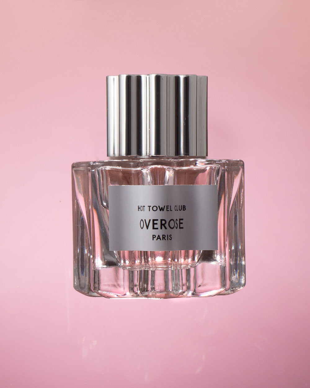 front view of 'hot towel club' perfume in front of a pink background