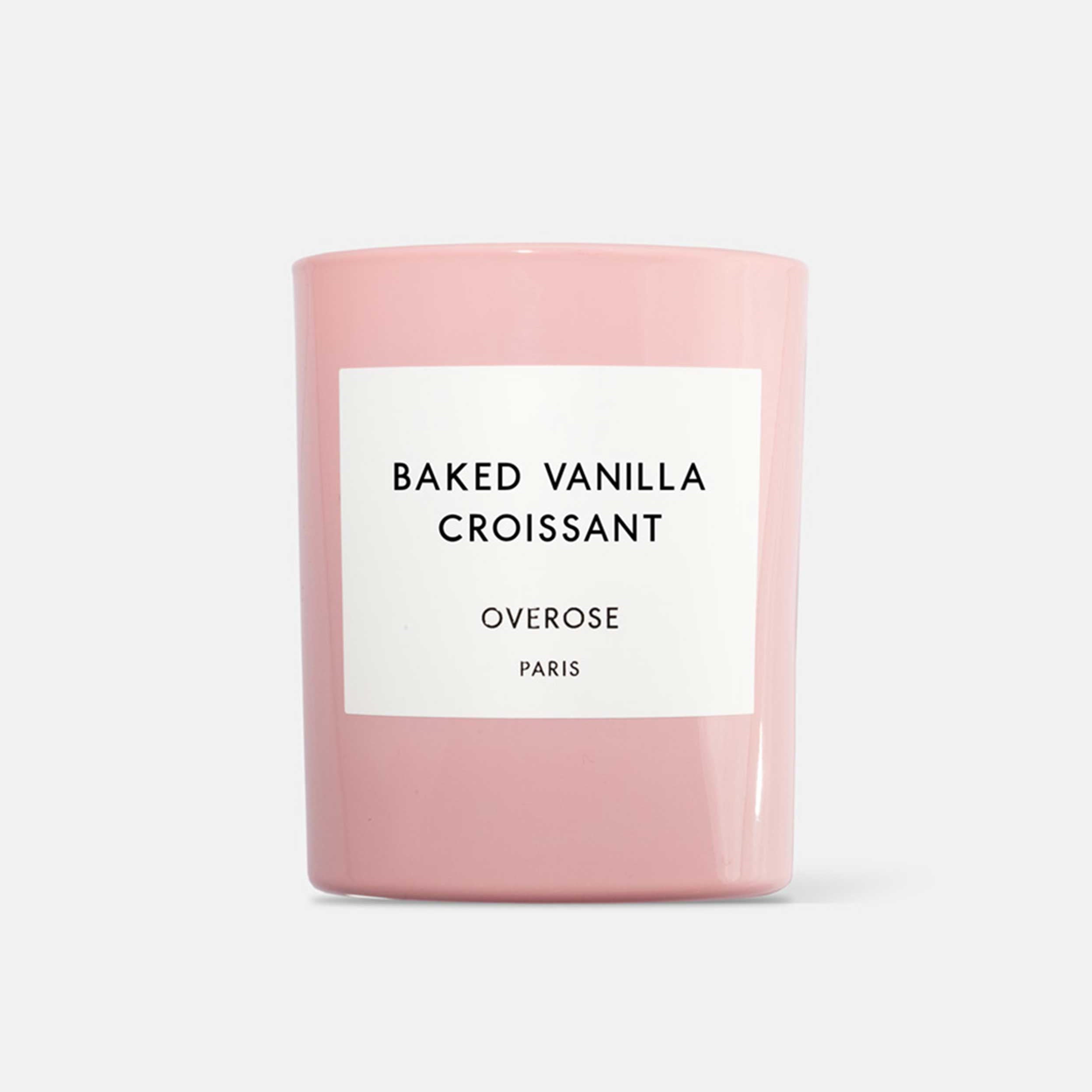 A pink candle labeled 'BAKED VANILLA CROISSANT' from the brand OVEROSE.