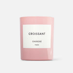 A pink candle with a white label that reads 'CROISSANT' and 'OVEROSE PARIS'.
