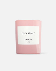 A pink candle with a white label that reads 'CROISSANT' and 'OVEROSE PARIS'.