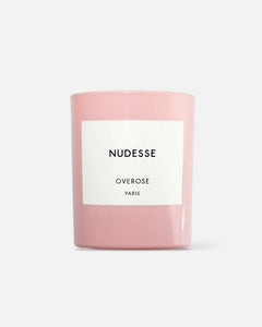 A pink candle with a white label that reads 'Nudesse Overose PARIS'.