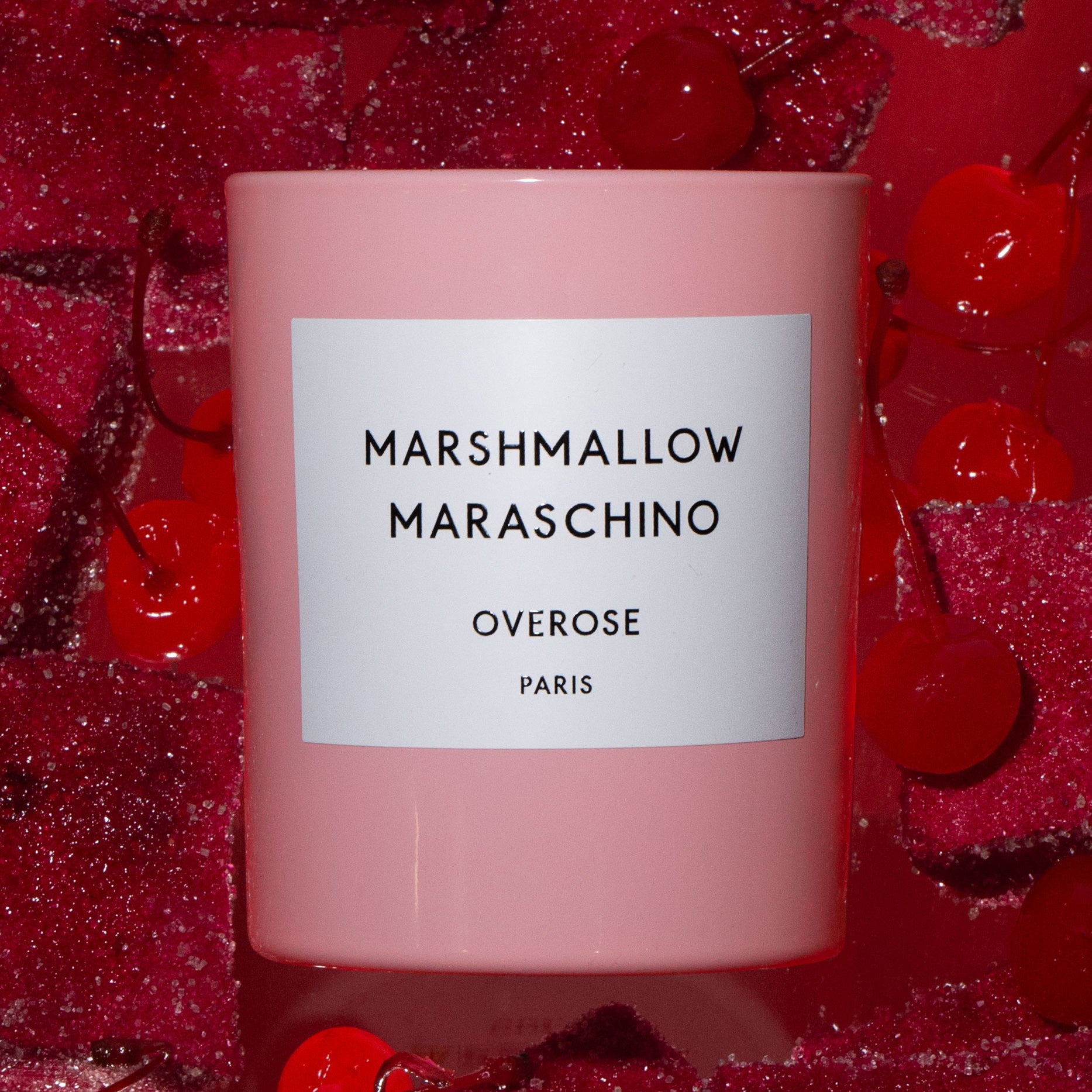 Pink candle with the name "Marshmallow Maraschino". Image background has cherry and marshmallows.