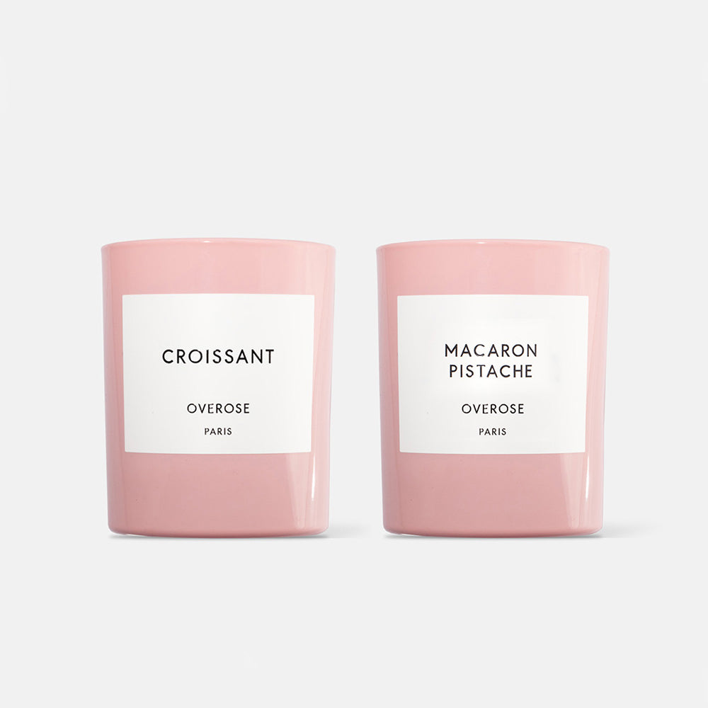Two pink candles, one labeled 'Croissant' and the other labeled 'Macaron Pistachio', both with 'OVEROSE PARIS' branding on the front.