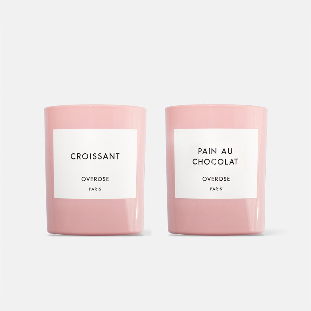 Two pink candles, one labeled 'Croissant' and the other labeled 'Pain au Chocolat', both with 'Overose, Paris' writing on the labels.