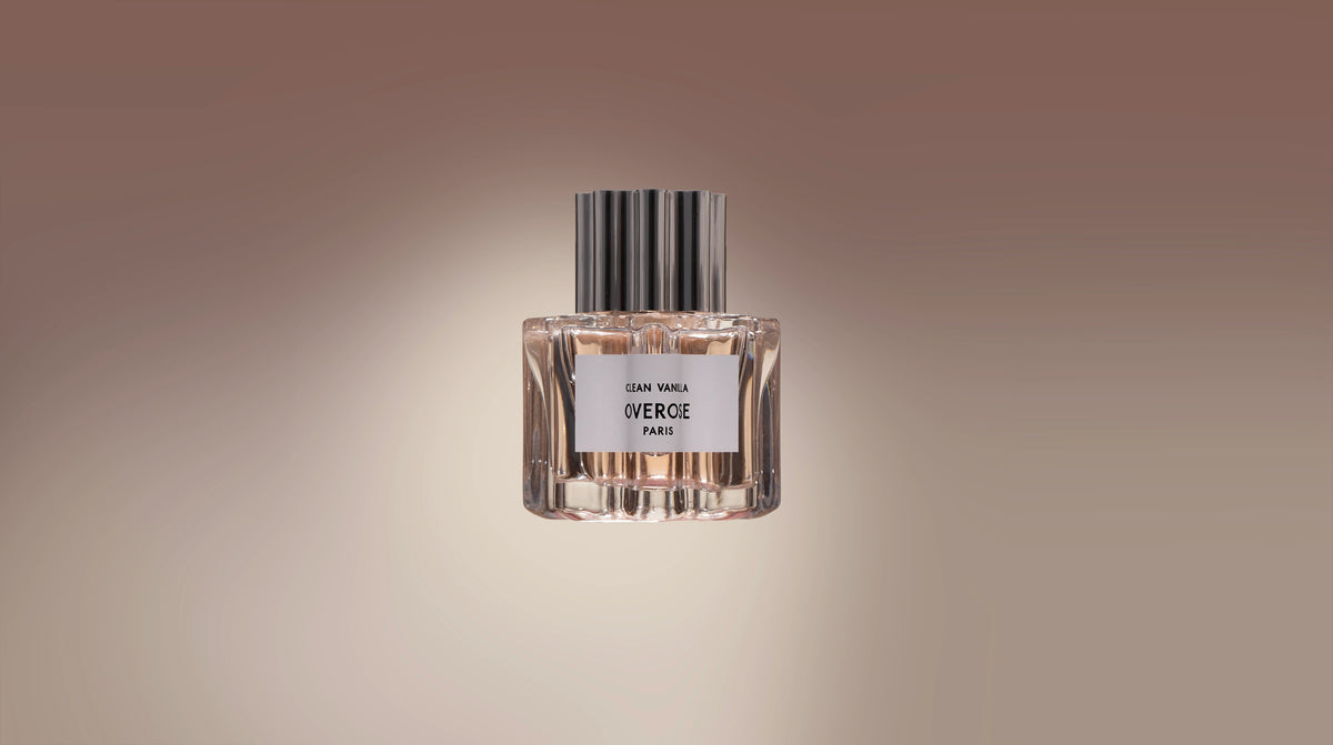 'clean vanilla' perfume bottle in front of pale brown background in a long banner format