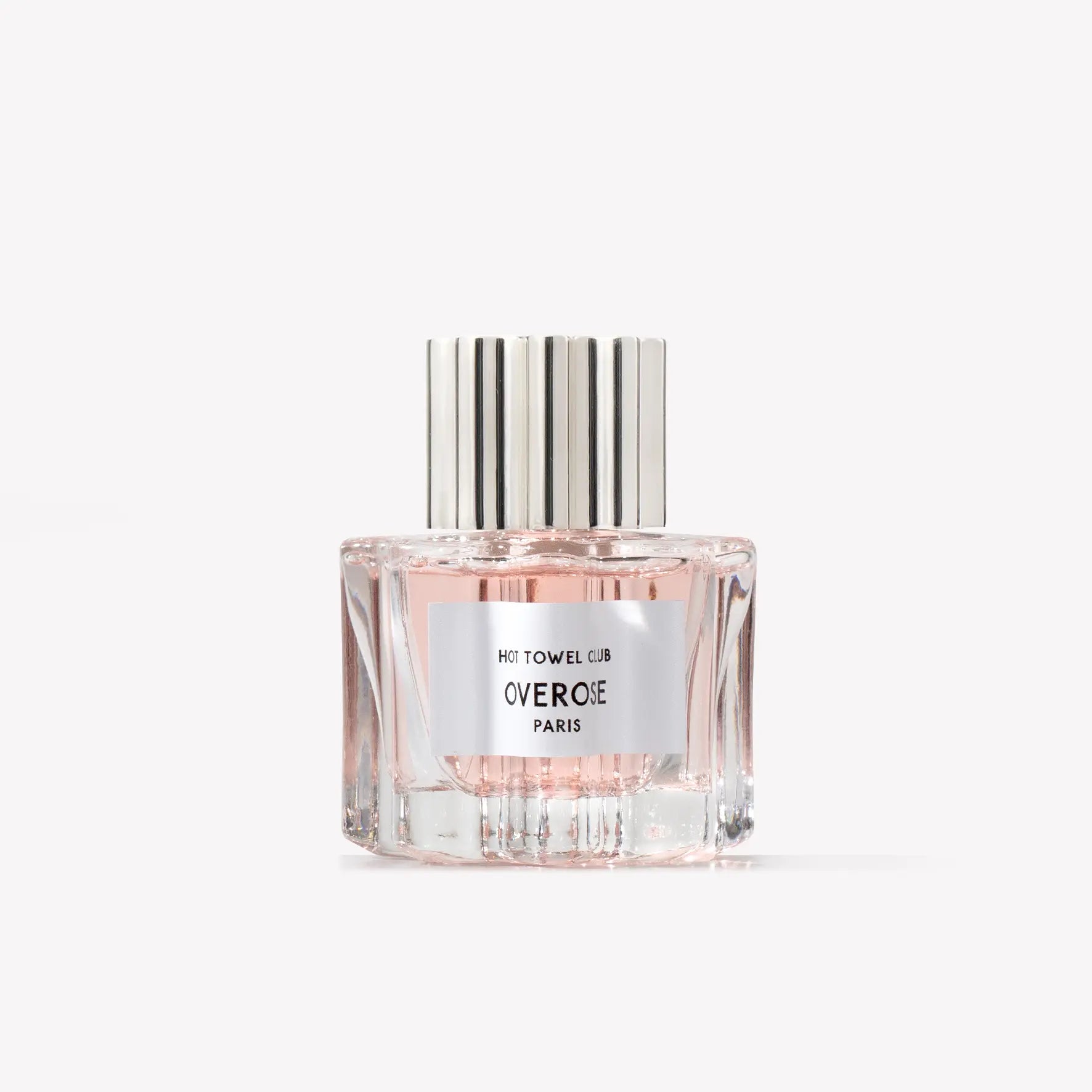 Perfume bottle with silver cap and pinkish body on a white background