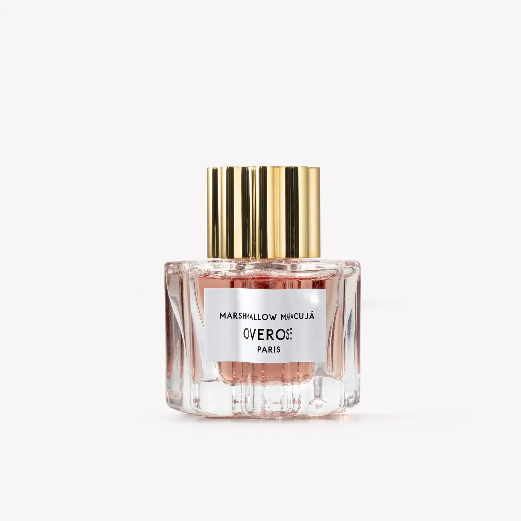 Perfume bottle with gold cap and white label on a light gray background