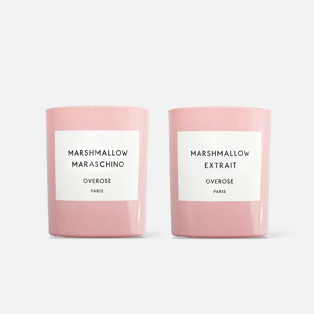 Two pink candles with white labels, one labeled 'Marshmallow Maraschino' and the other 'Marshmallow Extrait'.