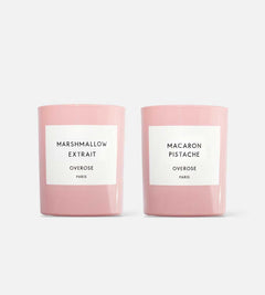 Two candles with pink glass jars, one labeled 'Marshmallow Extrait' and the other 'Macaron Pistachio'.